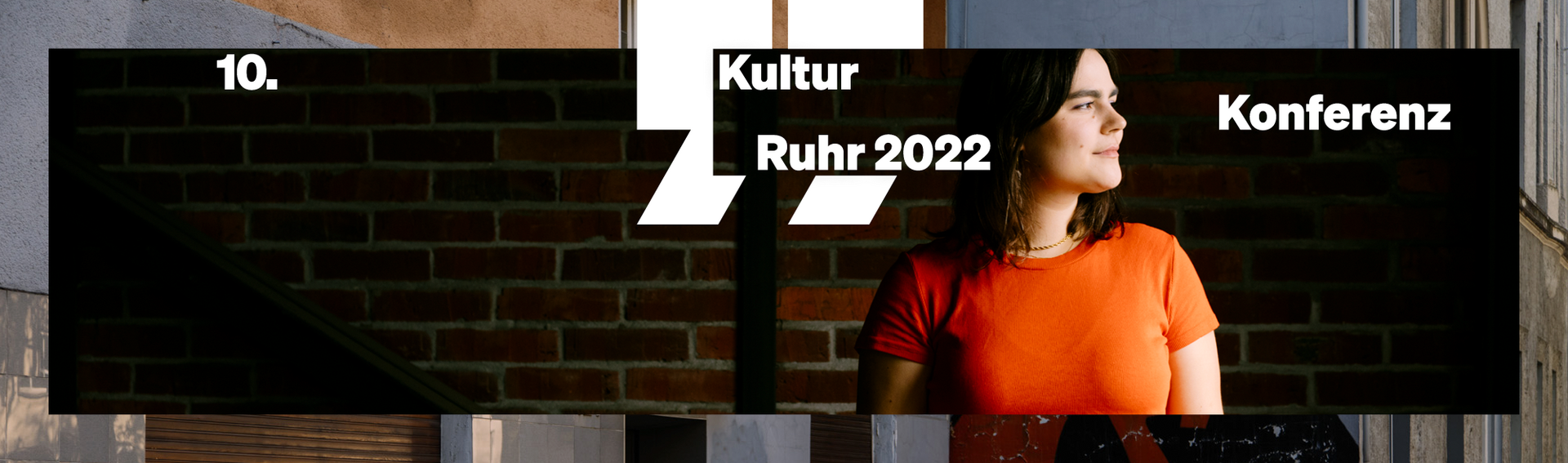 Frau mit orangefarbenem Shirt vor dunklem Hintergrund. Keyvisual "10. Kulturkonferenz Ruhr" eingebunden. eingebunden